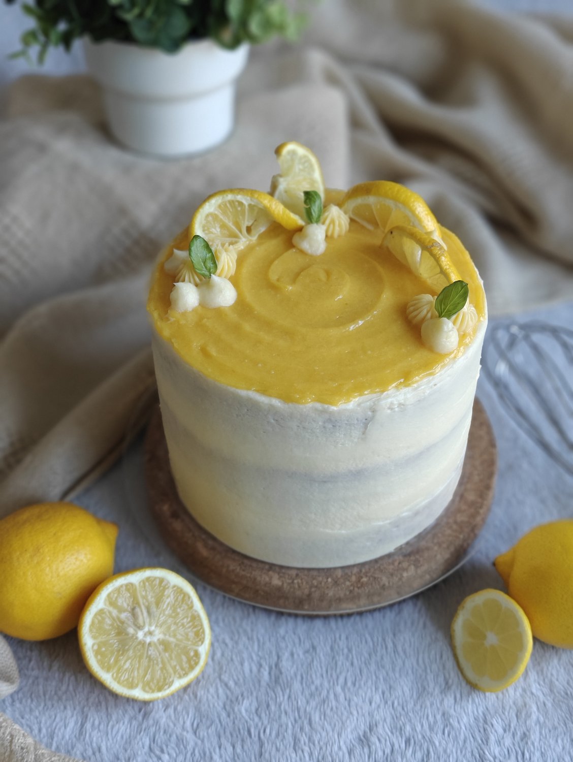 Two-tier lemon cake with candied lemon slices and meringue